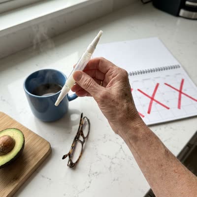 Overhead kitchen counter — near-empty NailScience Step 2 pen next to a calendar with three months X'd out